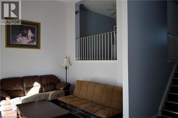 Kitchener townhouse for rent - A living room with a brown couch and a painting on the wall.
