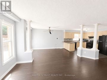 Kitchener apartment for rent - A spacious kitchen and living room with wood flooring and white walls.