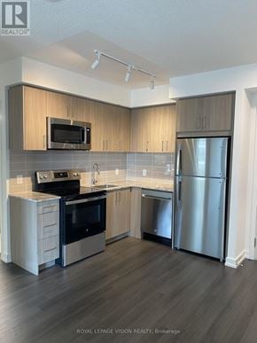 Toronto (Humber Heights) condo for rent - A modern kitchen with wooden cabinets and stainless steel appliances.