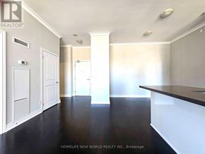 Mississauga (City Centre) condo for rent - A room with white walls and wooden floors, with a white door on the left and a white pillar in the middle of the room.