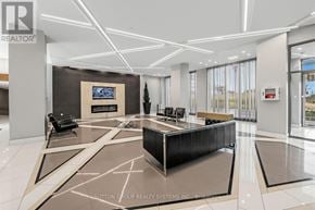 Mississauga (Hurontario) condo for rent - A modern office lobby with a reception desk and a large screen on the wall.