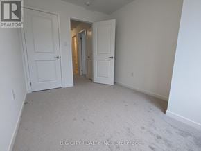 Oshawa (Samac) townhouse for rent - A room with white walls and carpeted floor with two doors.