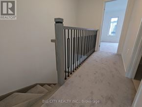 Oshawa (Samac) townhouse for rent - A hallway with a carpeted floor and a staircase with a wooden handrail.