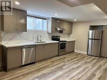 Essa apartment for rent - A modern kitchen with stainless steel appliances and wooden flooring.