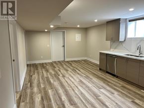 Essa apartment for rent - A room with wooden flooring and a kitchenette area.