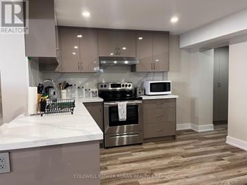 Essa apartment for rent - A modern kitchen with stainless steel appliances and wooden flooring.
