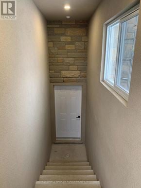 Essa apartment for rent - A hallway with a white door and a brick wall.