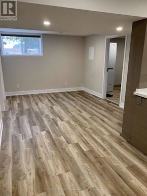 Essa apartment for rent - A room with wooden flooring and a doorway leading to another room.