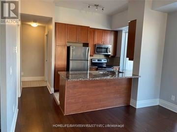 Markham (Unionville) condo for rent - A kitchen with wooden cabinets and a granite countertop.
