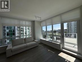 Vancouver apartment for rent - A spacious living room with a couch and large windows overlooking a cityscape.
