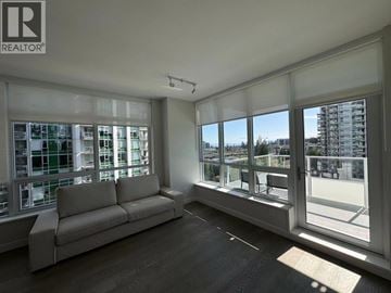 Vancouver apartment for rent - A spacious living room with a couch and large windows overlooking a cityscape.