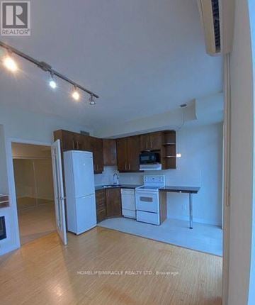 Mississauga (Fairview) condo for rent - A kitchen with white appliances and wooden cabinets.