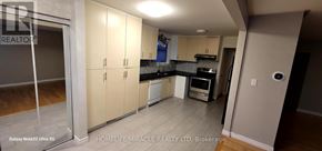 Mississauga (Clarkson) apartment for rent - A kitchen with white cabinets and a black countertop.