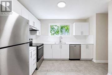Mississauga (Applewood) townhouse for rent - A kitchen with white cabinets and a stainless steel refrigerator.