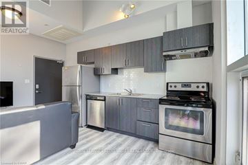 Waterloo condo for rent - A modern kitchen with stainless steel appliances and grey cabinets.