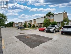 London townhouse for rent - A parking lot with cars and apartment buildings in the background.