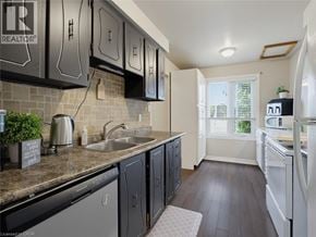 London townhouse for rent - A kitchen with black cabinets and a white refrigerator.