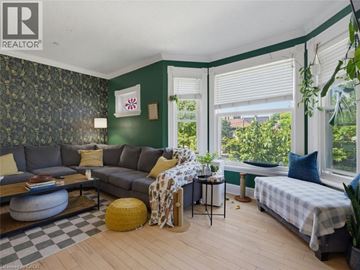 London apartment for rent - A living room with a grey couch and a green wallpaper.