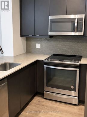 Mississauga (Central Erin Mills) condo for rent - A modern kitchen with a stainless steel oven and microwave.