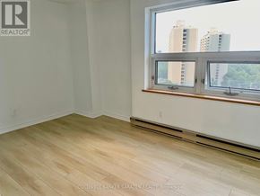 Ottawa condo for rent - A room with a window overlooking a cityscape.