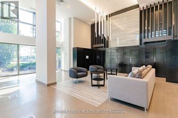 Richmond Hill (Langstaff) condo for rent - A modern living room with a large grey sofa and a black cabinet.