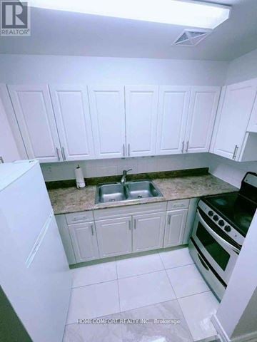 Toronto (Rexdale-Kipling) townhouse for rent - A kitchen with white cabinets and appliances.
