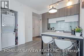 Toronto (Church-Yonge Corridor) condo for rent - A modern kitchen with white appliances and a dining table set up.