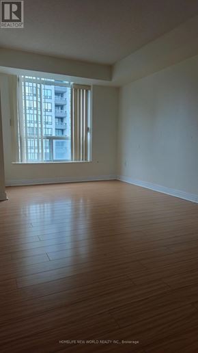 Toronto (Newtonbrook East) condo for rent - A room with wooden floors and a window showing a building outside.