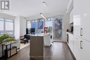 Toronto (Waterfront Communities) condo for rent - A modern kitchen with white cabinets and a wooden island.