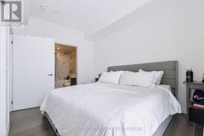 Toronto (Waterfront Communities) condo for rent - A bedroom with a large bed and a nightstand with a lamp.