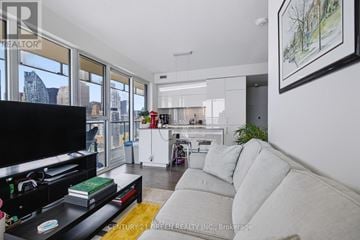 Toronto (Waterfront Communities) condo for rent - A living room with a grey couch and a flat screen TV.