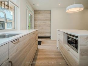 Pelham (Fonthill) townhouse for rent - A modern kitchen with wooden cabinets and a white countertop.