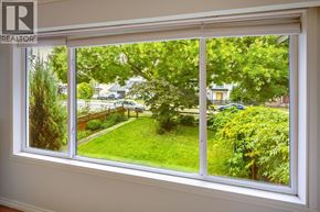 Burnaby apartment for rent - A window with a view of a green lawn and trees.