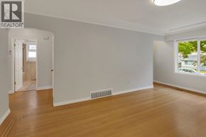 Burnaby apartment for rent - A room with wooden floors and white walls, with a window on the right side.