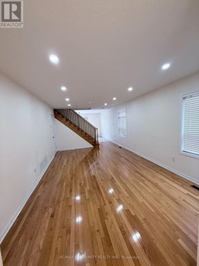 Toronto (Rouge) apartment for rent - A spacious room with wooden flooring and a staircase.