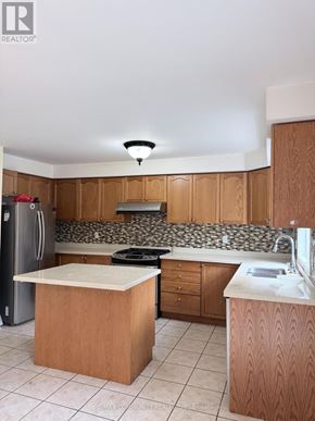 Toronto (Rouge) apartment for rent - A kitchen with wooden cabinets and a white counter top.