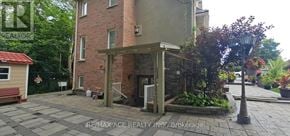 Toronto (Highland Creek) apartment for rent - A brick building with a small porch and a sign that says REMAX ACE REALTY INC. Brokerage.