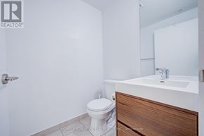 Markham (Wismer) condo for rent - A white bathroom with a toilet, sink, and mirror.