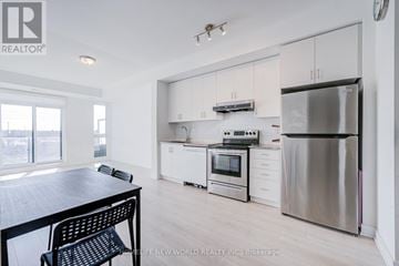 Markham (Wismer) condo for rent - A kitchen with a table and chairs in front of a window.