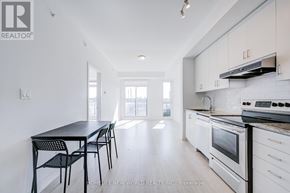 Markham (Wismer) condo for rent - A kitchen with white cabinets and black chairs.