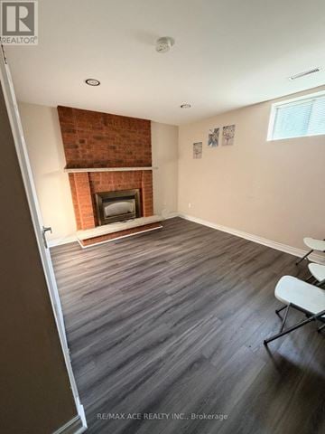 Toronto (Rouge) apartment for rent - A room with a fireplace and wood flooring.