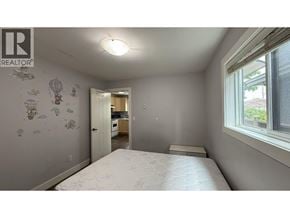 Burnaby apartment for rent - A bedroom with a bed, a window, and a wall with drawings on it.