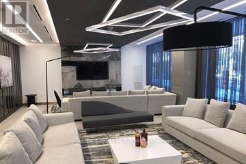 Toronto (Kensington-Chinatown) condo for rent - A modern living room with a large grey sofa and a white coffee table.