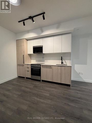 Toronto (Centennial Scarborough) condo for rent - A modern kitchen with wooden cabinets and a stainless steel oven.