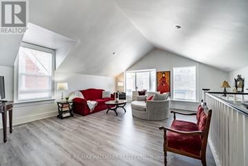 Whitchurch-Stouffville (Stouffville) apartment for rent - A living room with a red couch and a wooden floor.