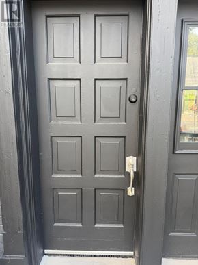 Whitchurch-Stouffville (Stouffville) apartment for rent - A grey door with a keyhole and a key in it.