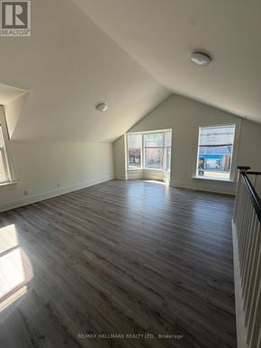 Whitchurch-Stouffville (Stouffville) apartment for rent - A spacious room with wooden flooring and a large window.