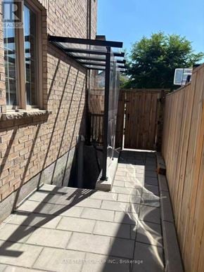 Markham (Greensborough) apartment for rent - A sunny day at a Bay Street Group Inc. Brokerage property with a wooden fence and a brick wall.