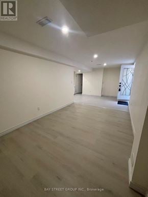 Markham (Greensborough) apartment for rent - A spacious room with wooden flooring and white walls, with a door on the right side.