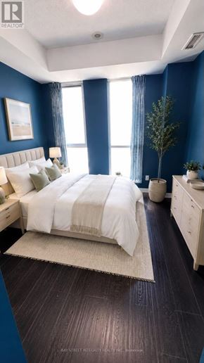 Toronto (Regent Park) condo for rent - A bedroom with a bed, nightstand, and a plant.